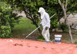 Man painting a tile roof